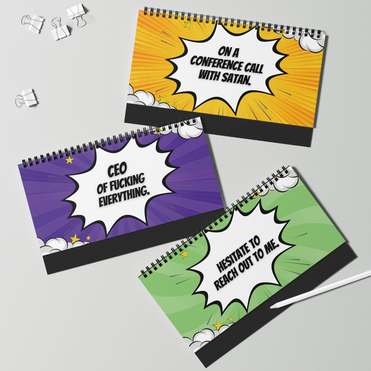 Three desk sign pages with colorful designs and text on a gray background