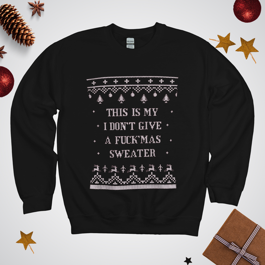 Black sweater with white text and patterns on a light gray background with Christmas decorations.
