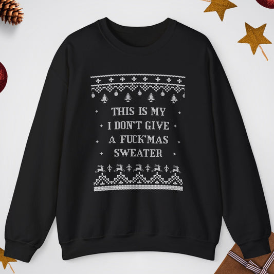 Black sweater with white text and patterns on a light gray background with Christmas decorations.