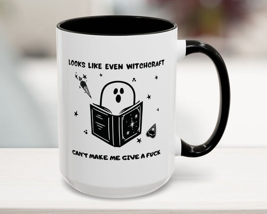 White mug with black interior and handle, featuring a ghost reading a book graphic and text.