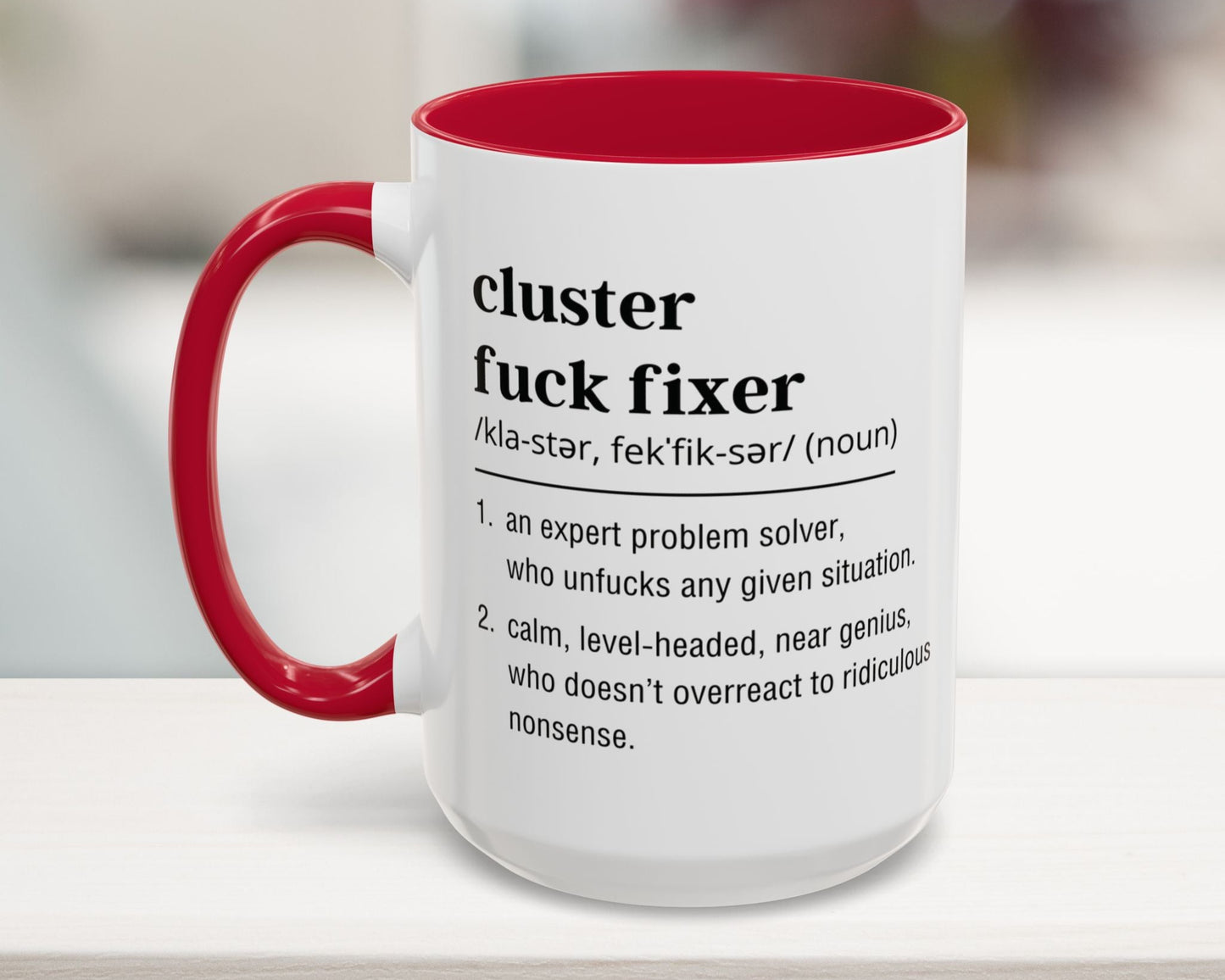 Mug with red interior and handle, featuring text on a blurred background
