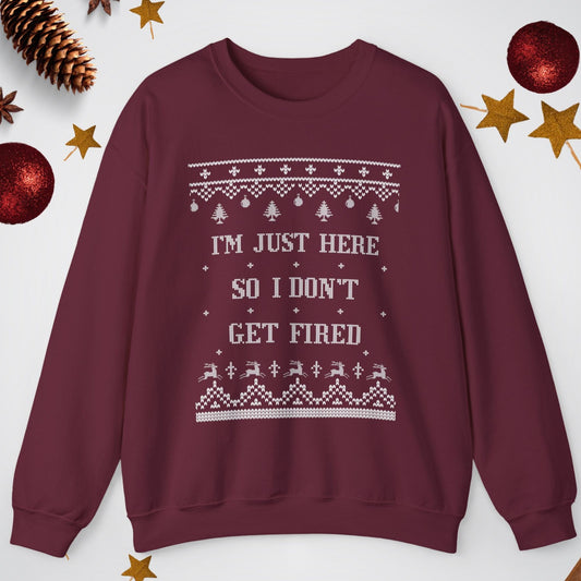 Maroon sweatshirt with text and patterns on a white background with Christmas decorations.
