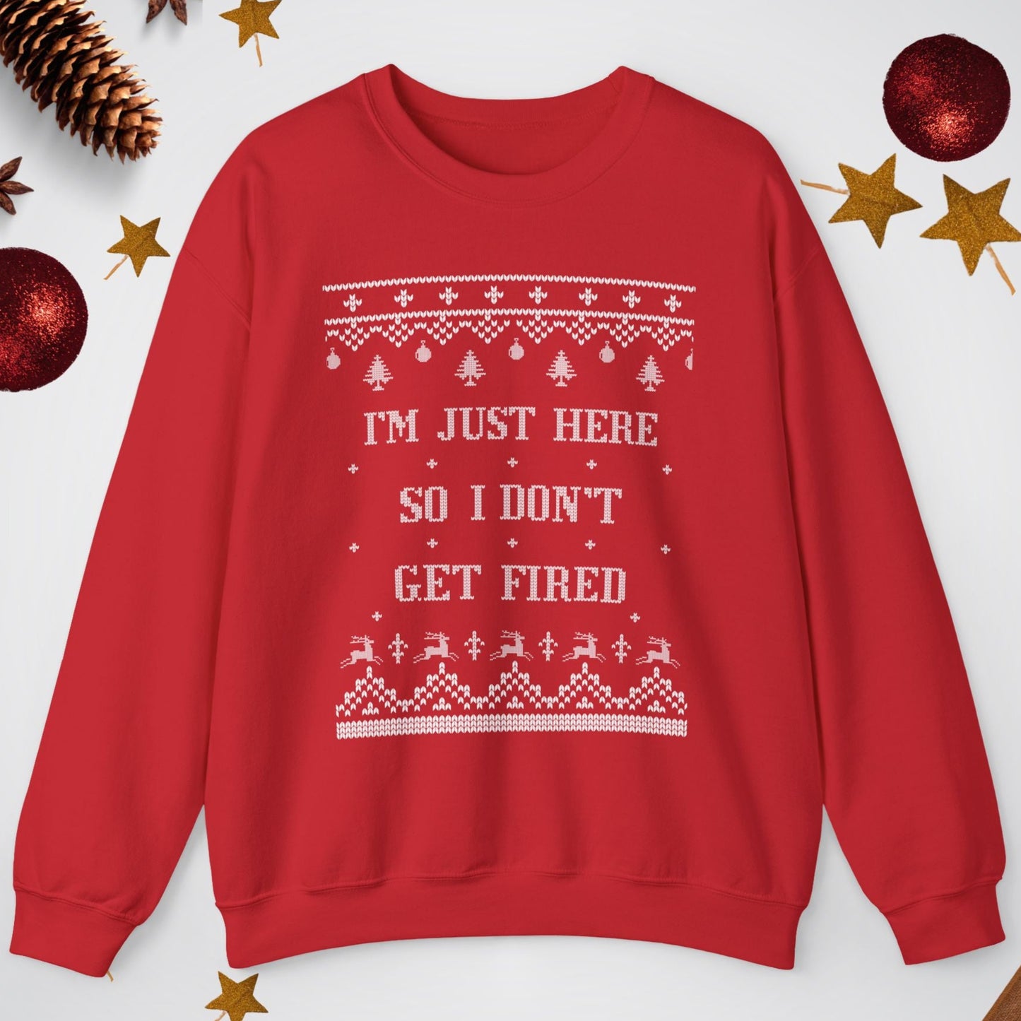 Red sweatshirt with text 'I'm just here so I don't get fired' on a white background with Christmas decorations.