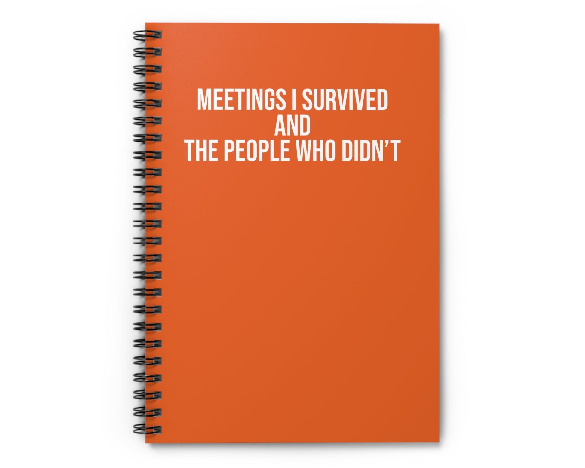 Orange notebook with text 'MEETINGS I SURVIVED AND THE PEOPLE WHO DIDN'T' on a white background