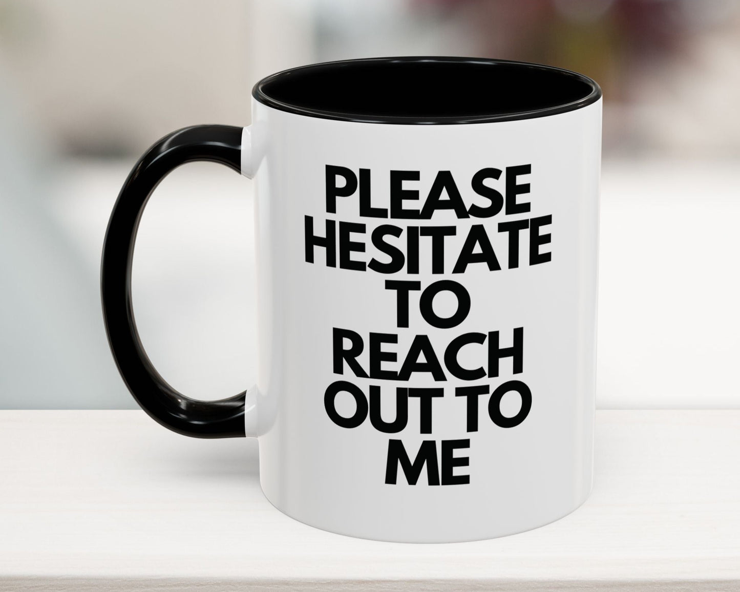 White mug with black interior and handle, featuring text on a blurred background