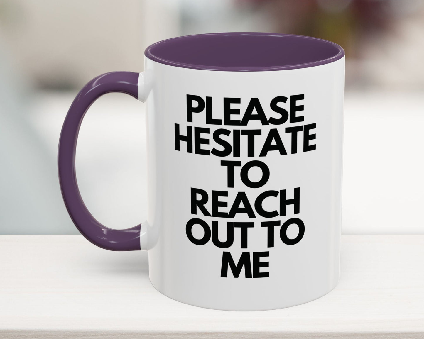 White mug with purple handle and interior, featuring text on a blurred background