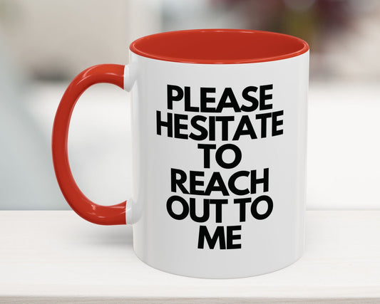White mug with red interior and handle, featuring black text on a blurred background