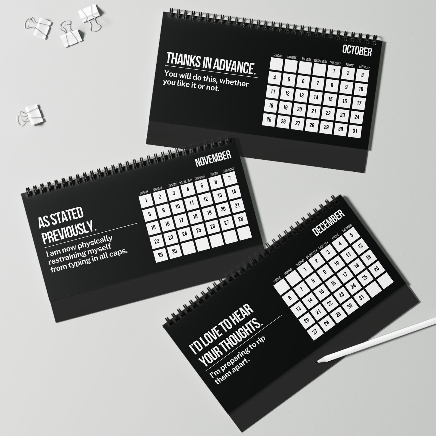 Three black spiral-bound calendars for October, November, and December on a light gray background.