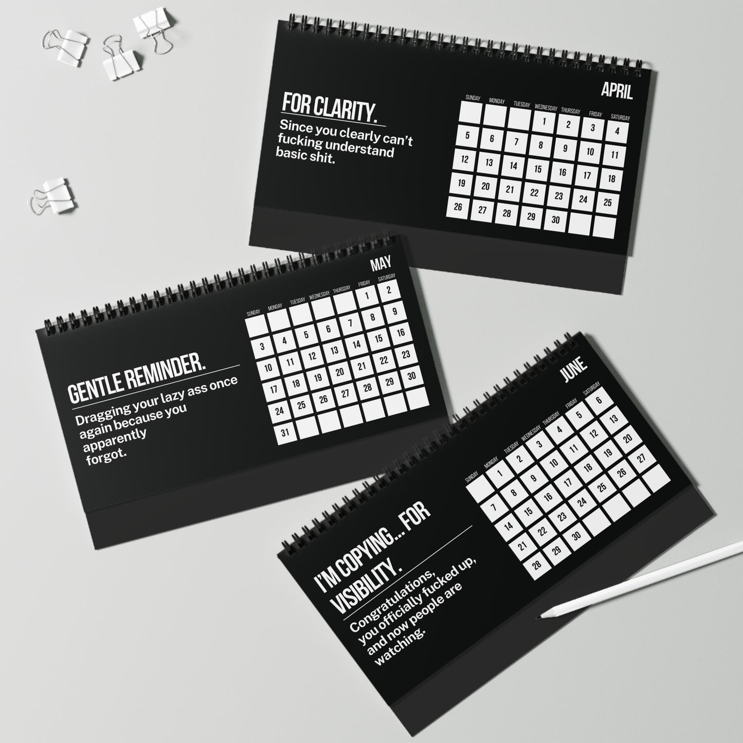 Three black spiral-bound calendars for April, May, and June with humorous text on a gray background.
