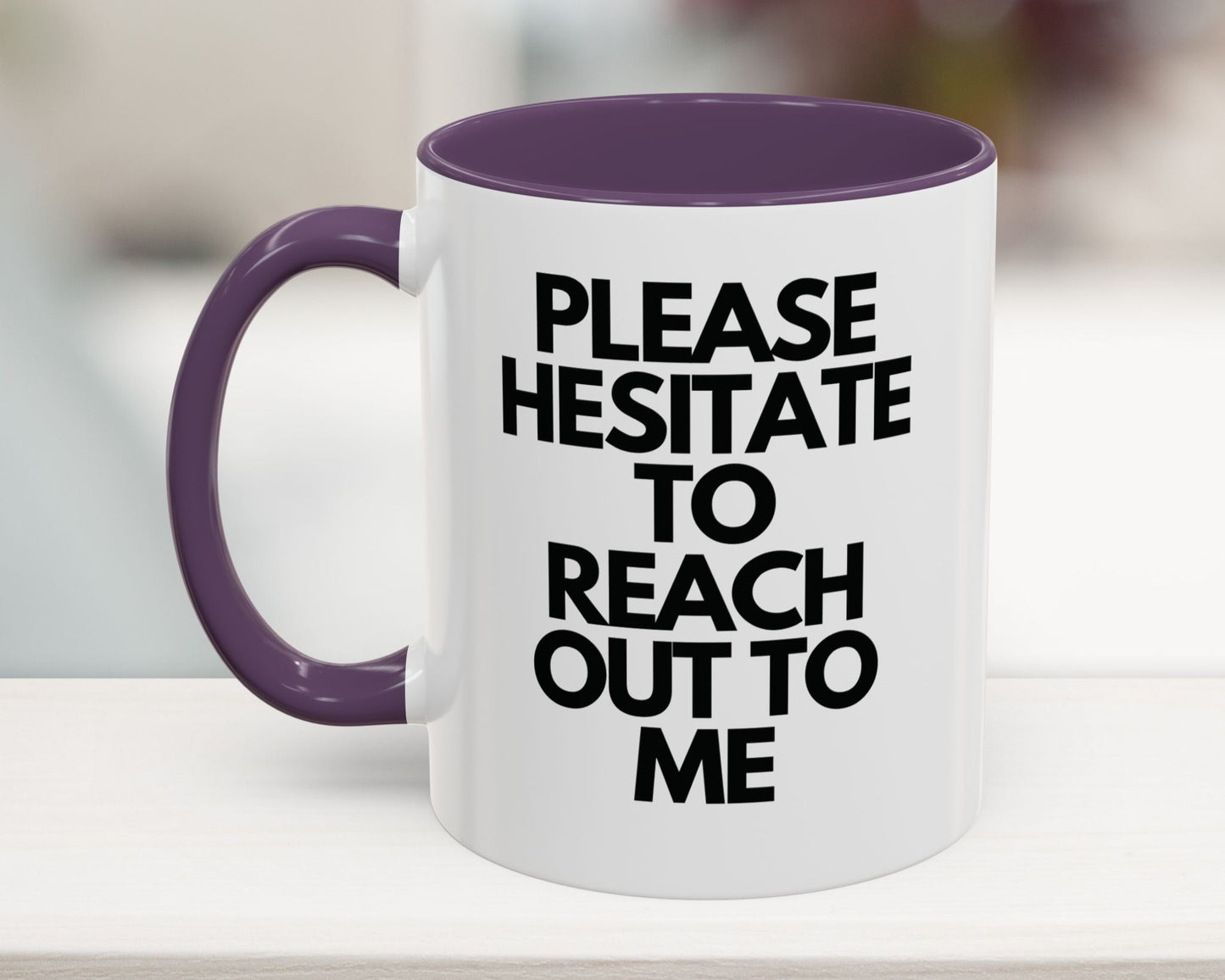 White mug with purple handle and interior, featuring text on a blurred background
