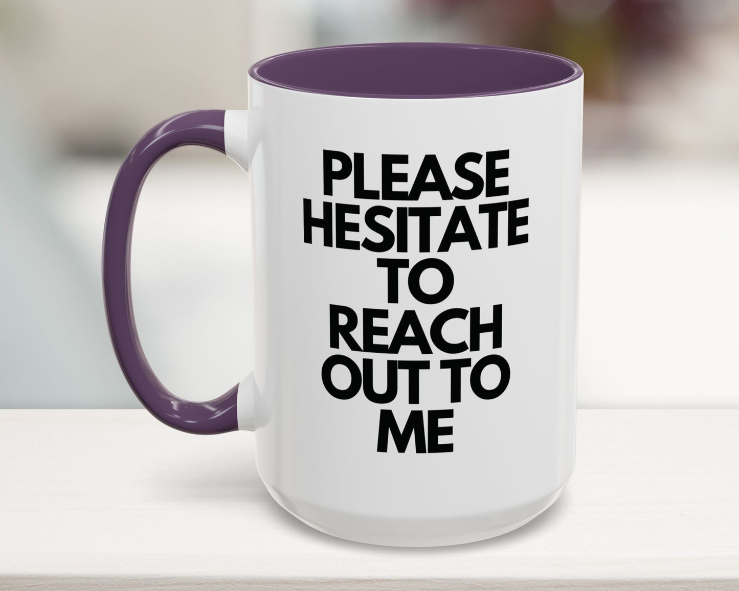 White mug with purple handle and interior, featuring text on a blurred background