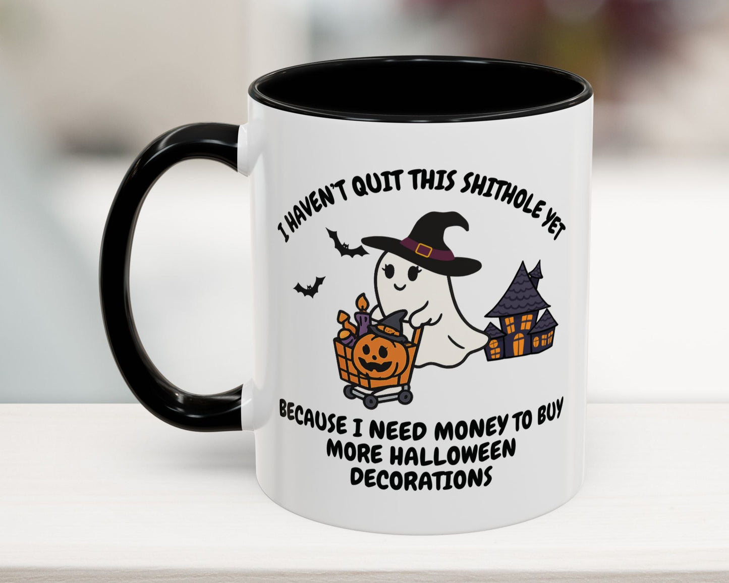 White mug with black handle featuring a Halloween-themed ghost design and text.