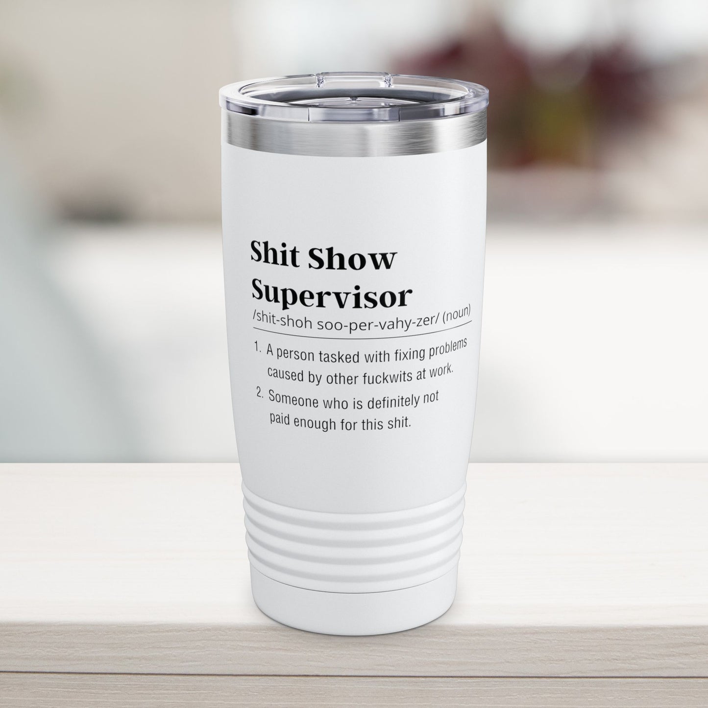 Shit show supervisor White tumbler with black text on a blurred background