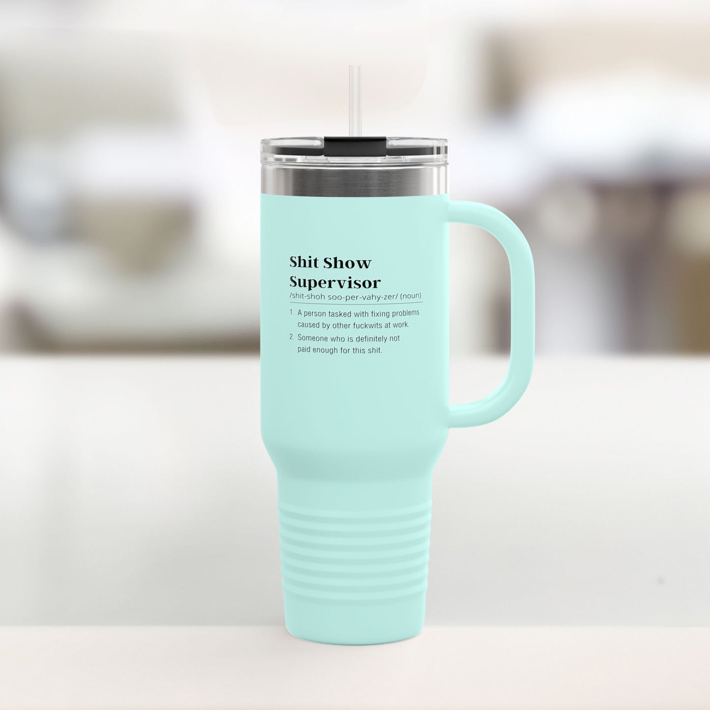 Shit show supervisor Mint green travel mug with text on a blurred background