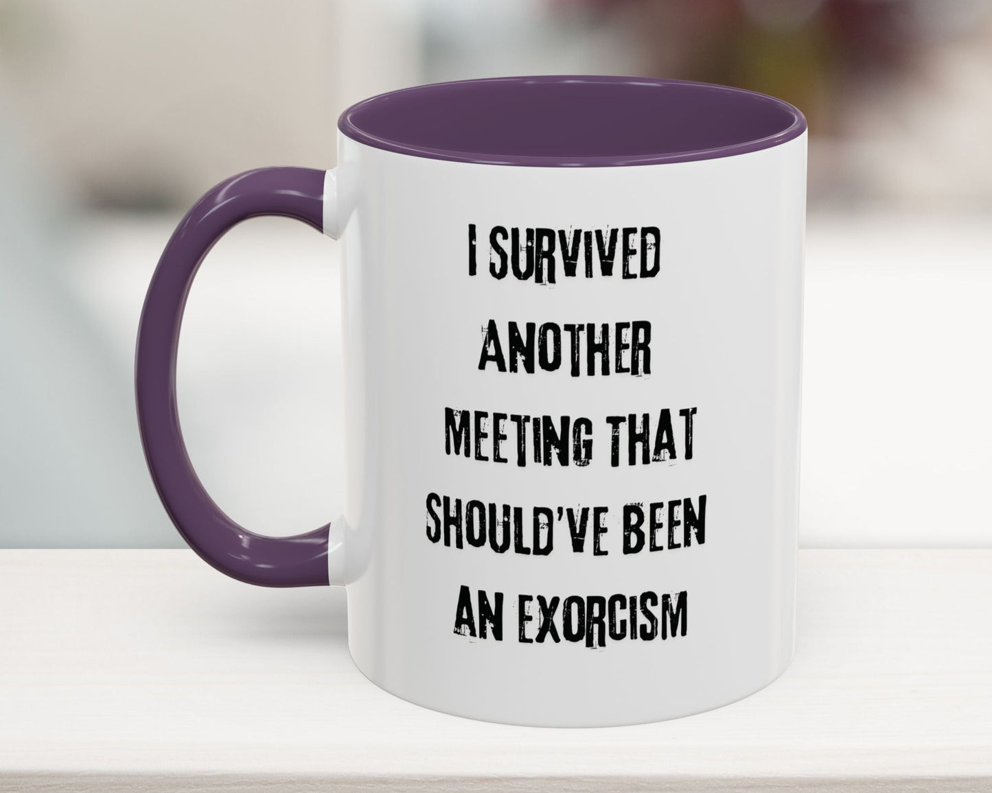 White mug with purple handle and interior, featuring text on a blurred background