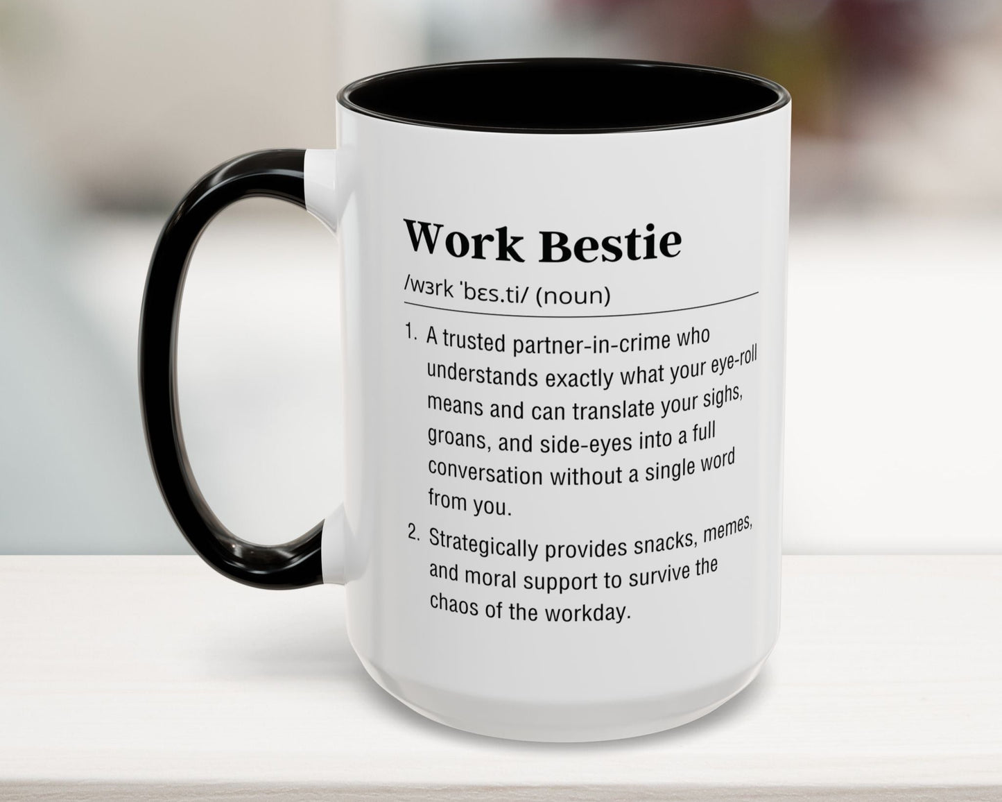Mug with text definition of 'Work Bestie' on a blurred background