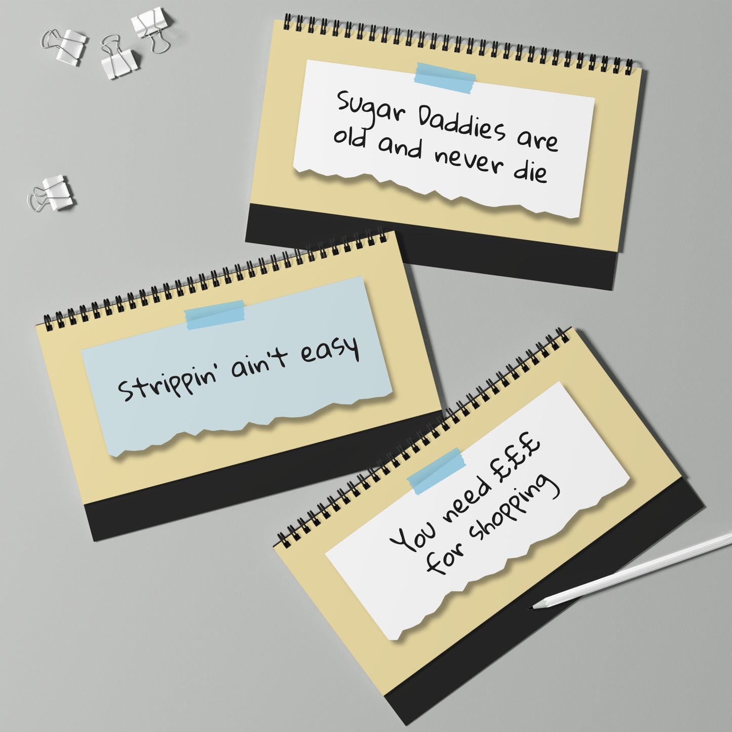 Three spiral-bound notebooks with text on a gray background