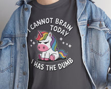 Person wearing a dark gray t-shirt with a unicorn graphic and text, paired with a denim jacket.