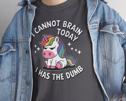Person wearing a dark gray t-shirt with a unicorn graphic and text, paired with a denim jacket.