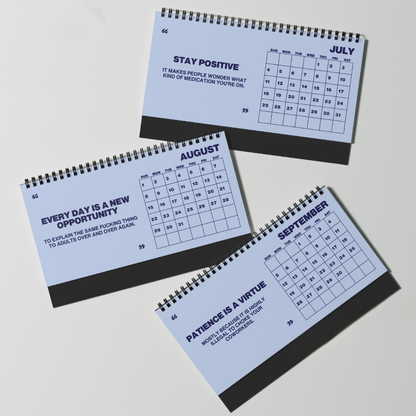 Three spiral-bound monthly desk calendars for October, November, and December, arranged diagonally on a light gray background. Each calendar has a pale blue cover with dark gray text and a dark gray spiral binding edge.