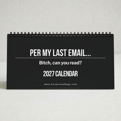 A black spiral-bound 2027 desk calendar with white text reading 'PER MY LAST EMAIL.