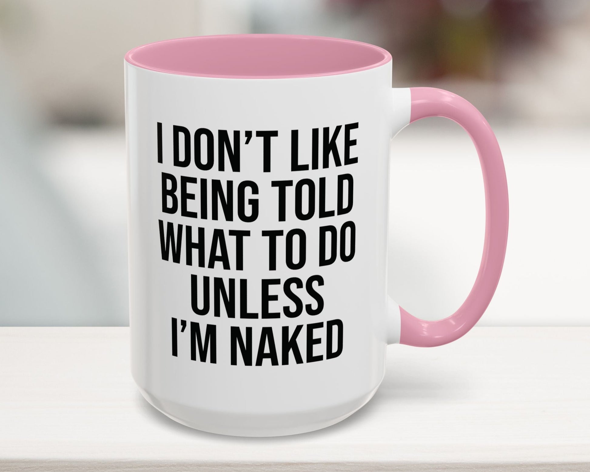 White mug with pink interior and handle, featuring a humorous quote.