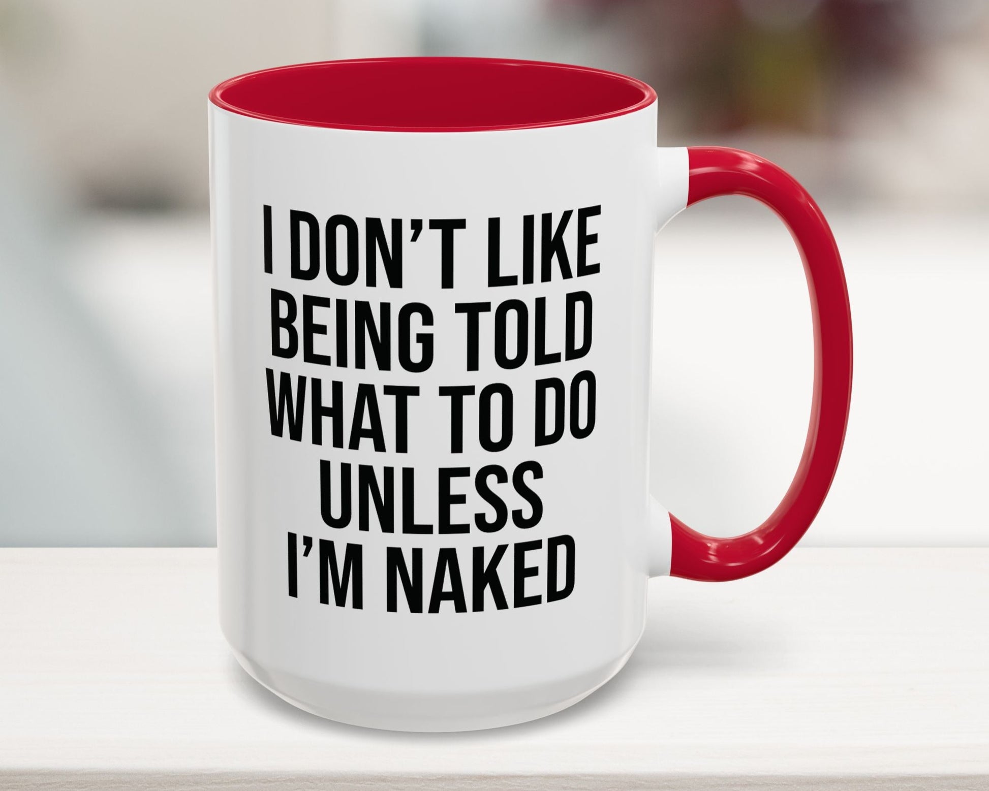 White mug with red interior and handle, featuring a humorous quote.