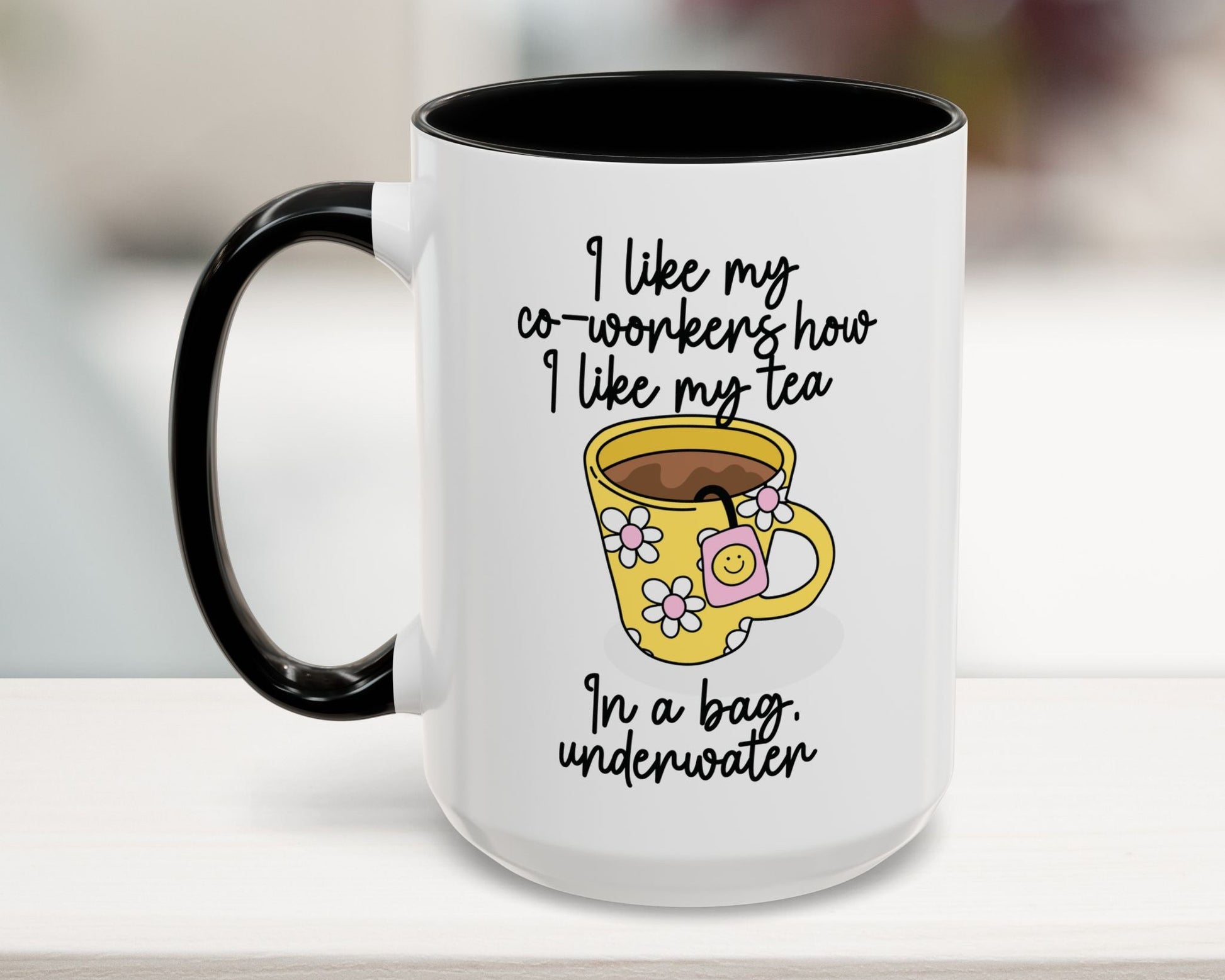White mug with black interior and handle, featuring a yellow coffee cup graphic and text on a light wooden surface.