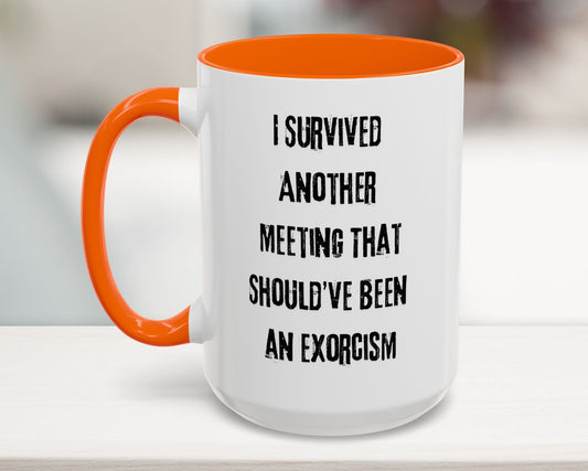 White mug with orange handle and interior, featuring text on a blurred background