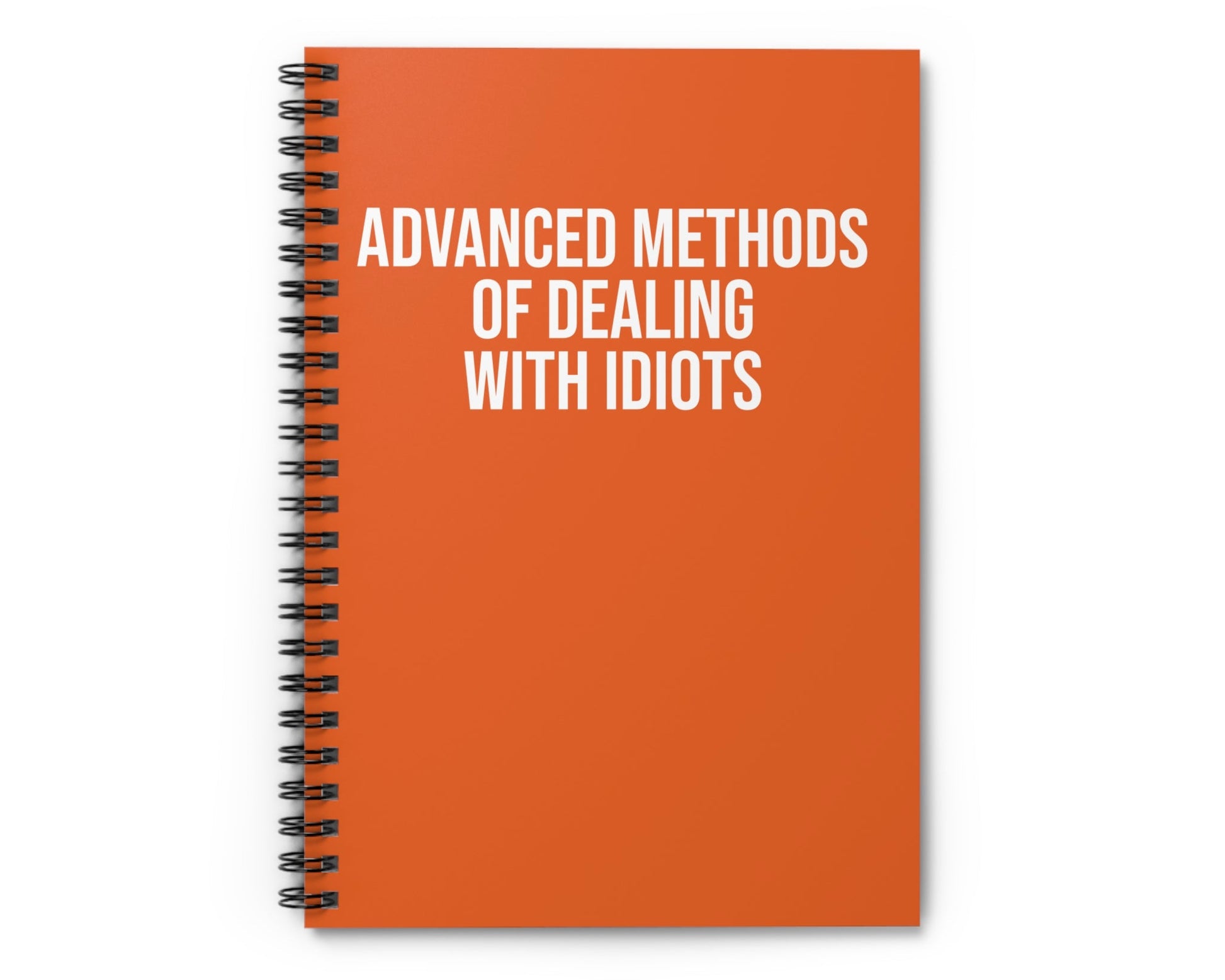 Orange notebook with 'Advanced Methods of Dealing with Idiots' text on a white background