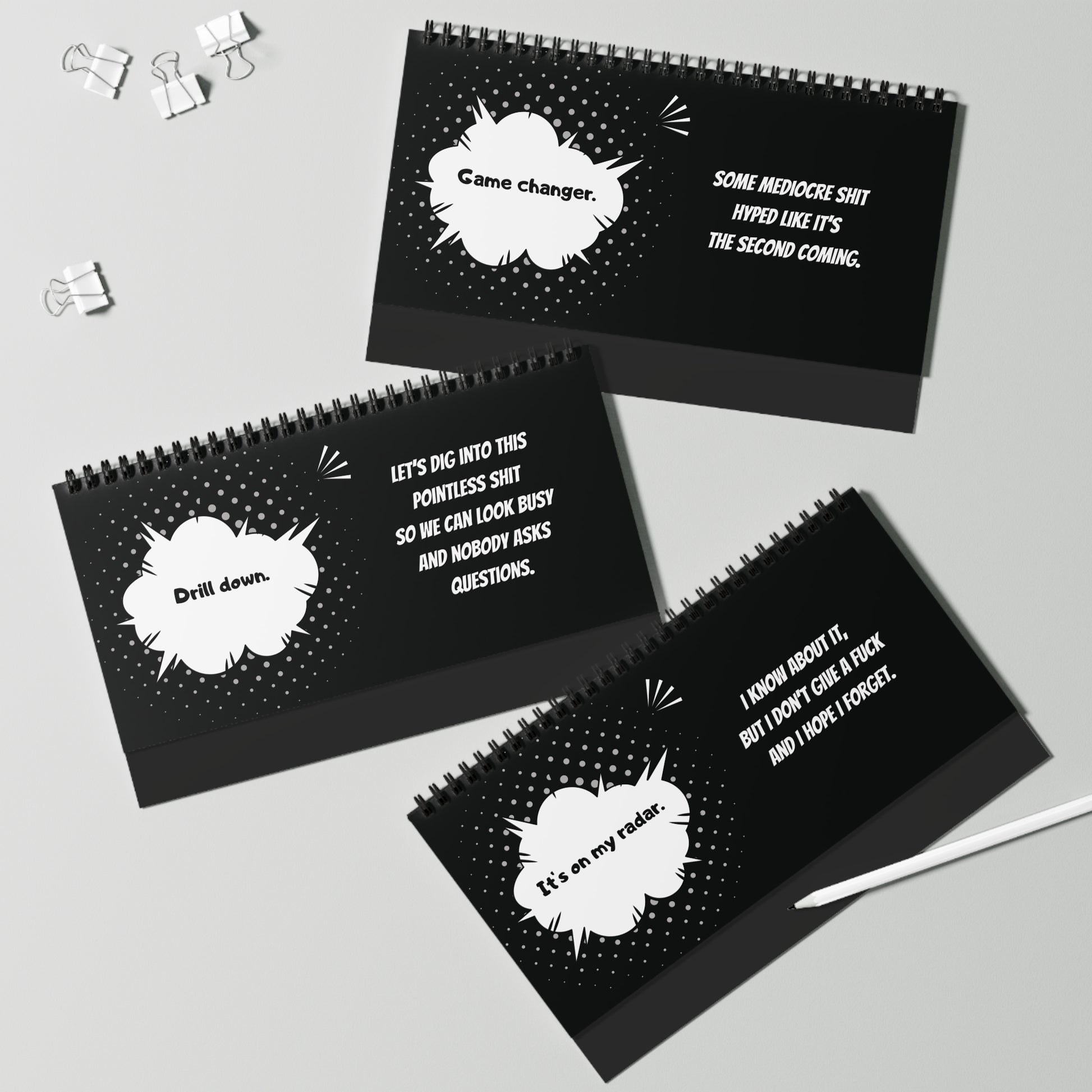 Black spiral-bound pages with white text and comic book-style speech bubbles on a gray background.