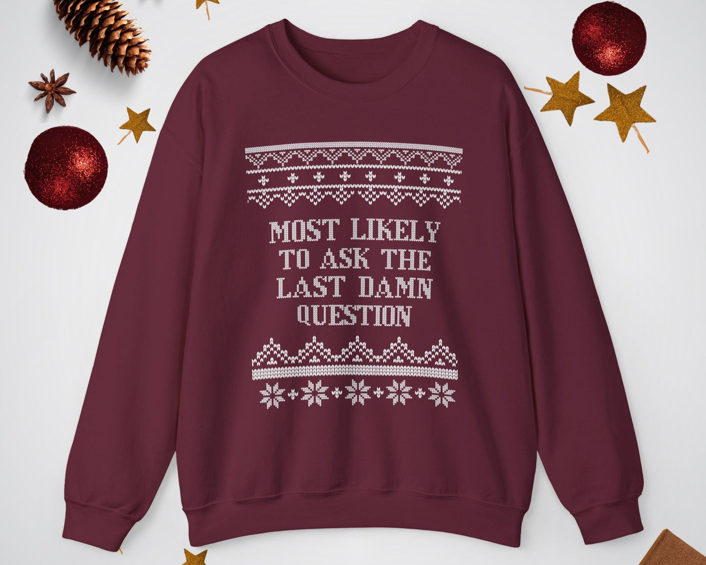 Maroon sweatshirt with text and patterns on a white background with Christmas decorations.