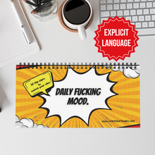 Desk sign with explicit language text on a desk with coffee and office supplies.