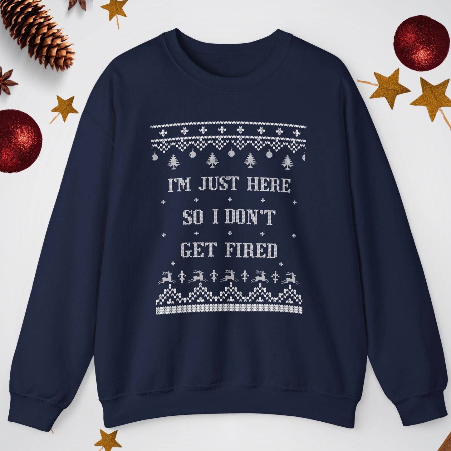 Navy blue sweater with white text and patterns on a light gray background with Christmas decorations.