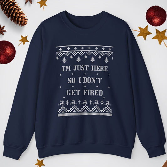 Navy blue sweater with white text and patterns on a light gray background with Christmas decorations.