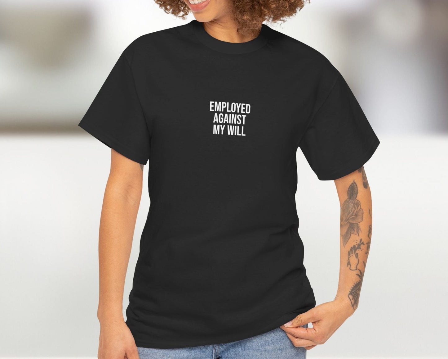 Woman wearing a black t-shirt with text, standing against a blurred background