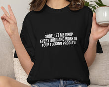 Person wearing a black t-shirt with text, holding a mug in a casual setting.