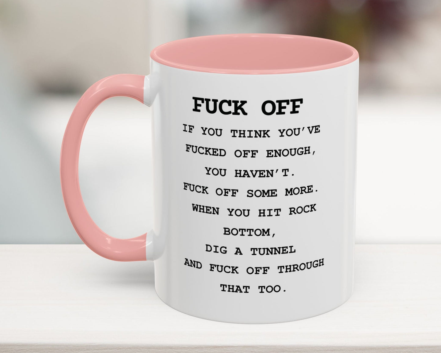 White mug with pink handle and interior, containing a message.
