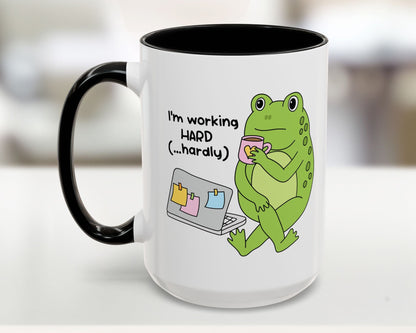 White mug with a green frog illustration and text on a blurred background