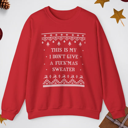Red sweater with white text and patterns on a light gray background with Christmas decorations.