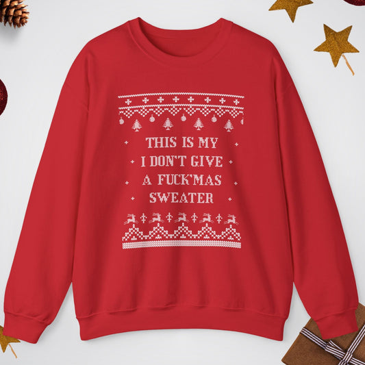 Red sweater with white text and patterns on a light gray background with Christmas decorations.