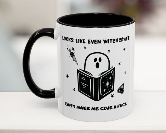 Mug with ghost reading a book design and text on a white surface.