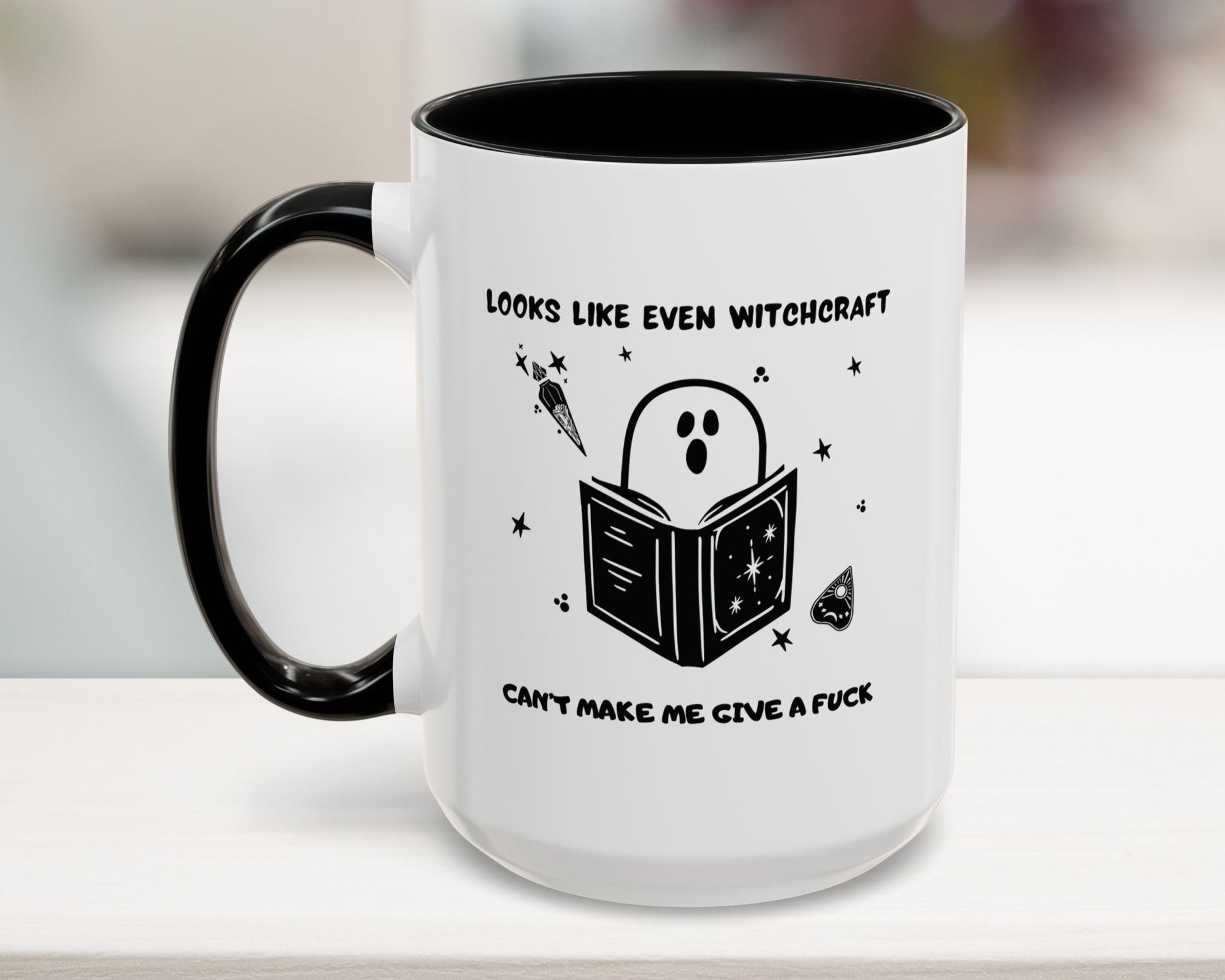 White mug with black interior and handle, featuring a ghost reading a book design and text.