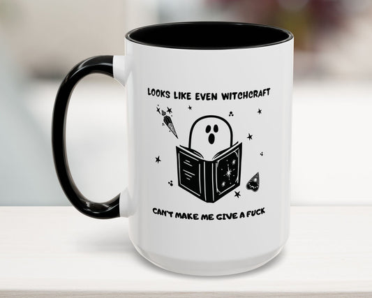 White mug with black interior and handle, featuring a ghost reading a book design and text.