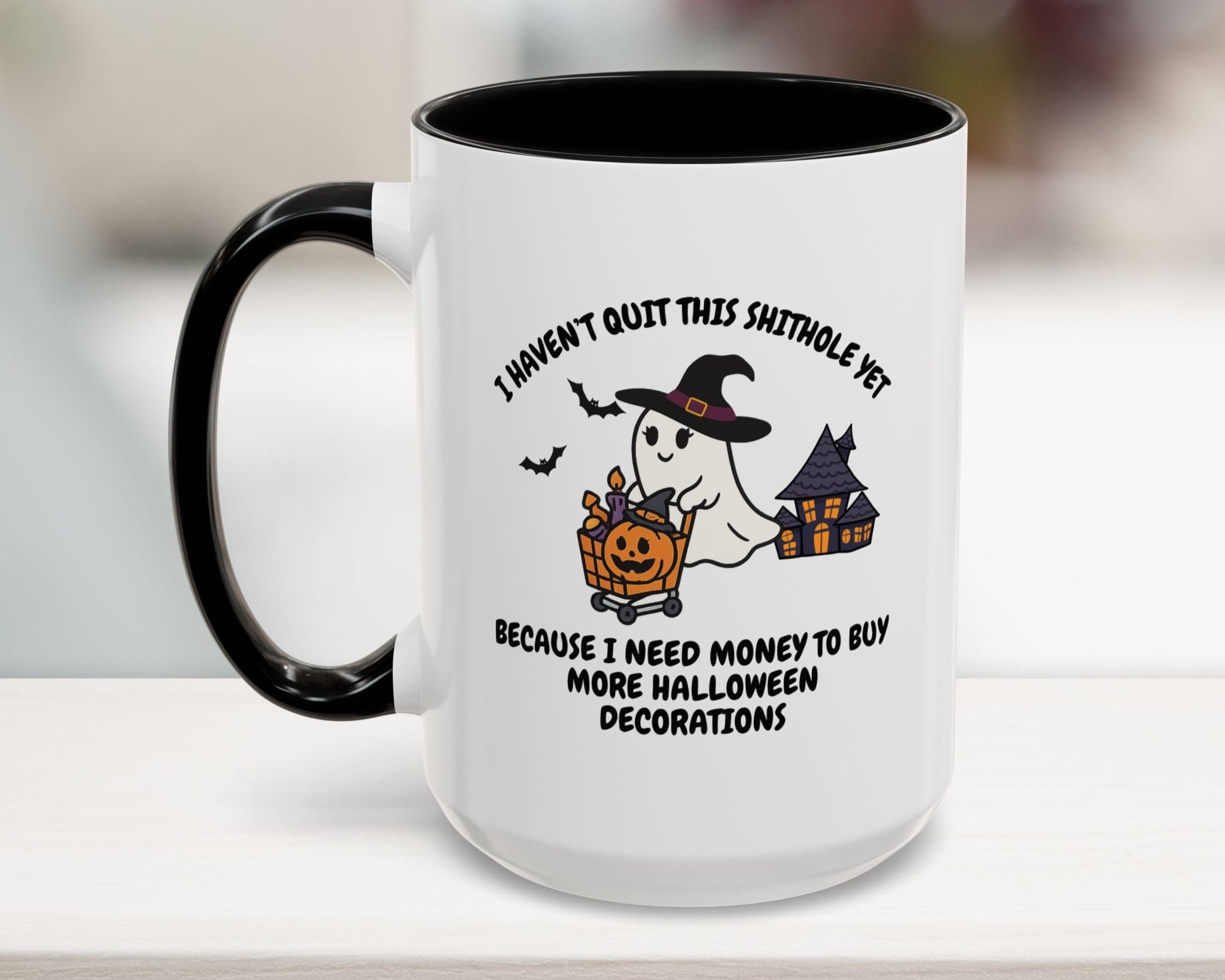 White mug with black interior and handle, featuring a Halloween-themed design and text.