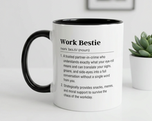 Mug with definition of 'Work Bestie' on a white surface with a plant in the background