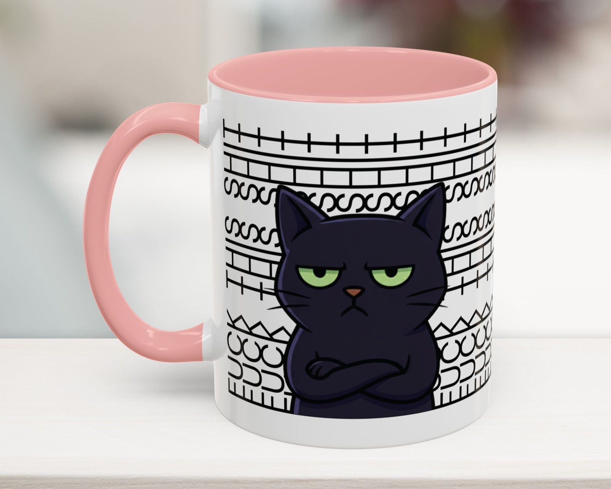 Mug with a black cat design and pink handle on a blurred background