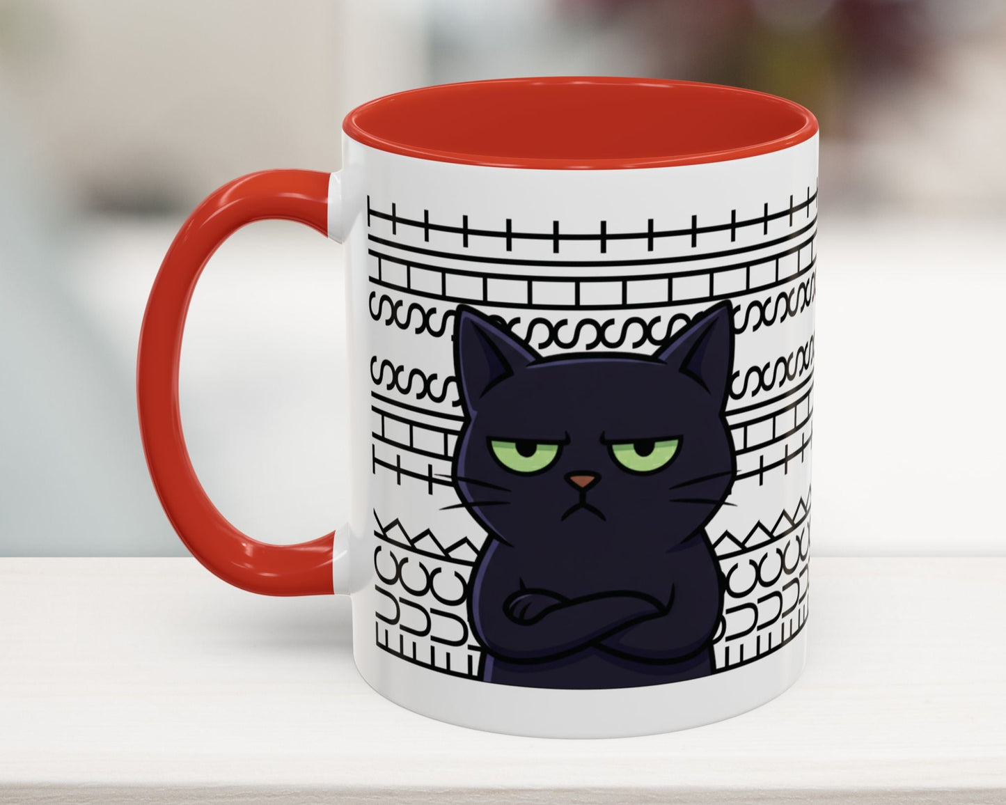 Mug with a black cat design and red handle on a white surface