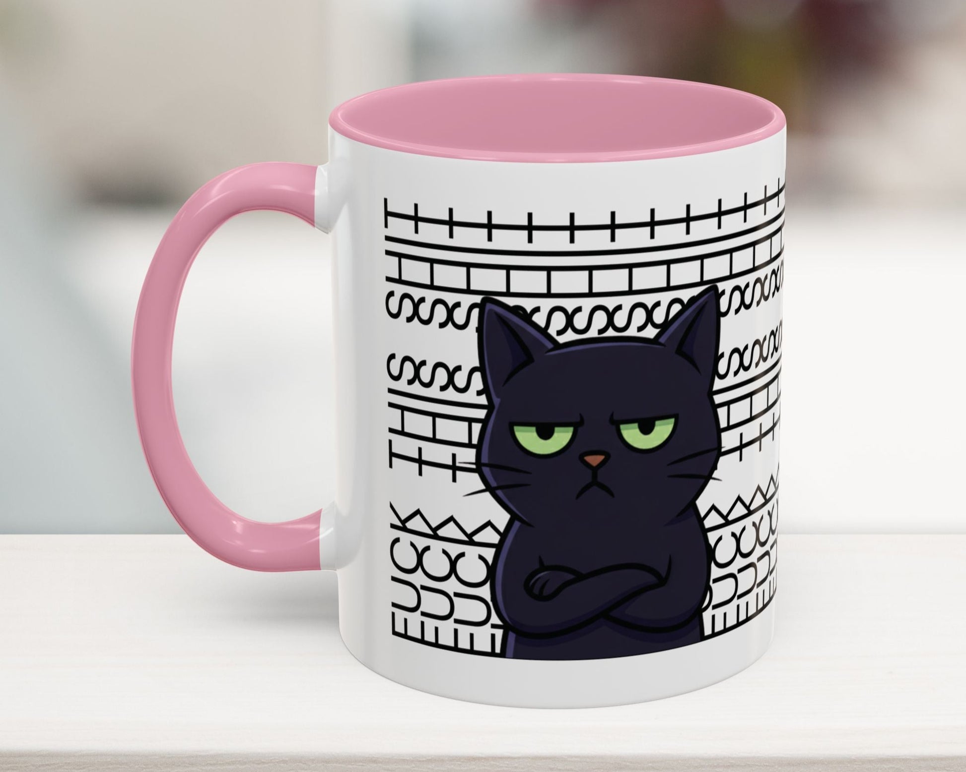 Mug with a black cat design and pink handle on a blurred background