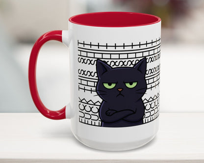 White mug with red interior and handle, featuring a black cat illustration and text on a blurred background.